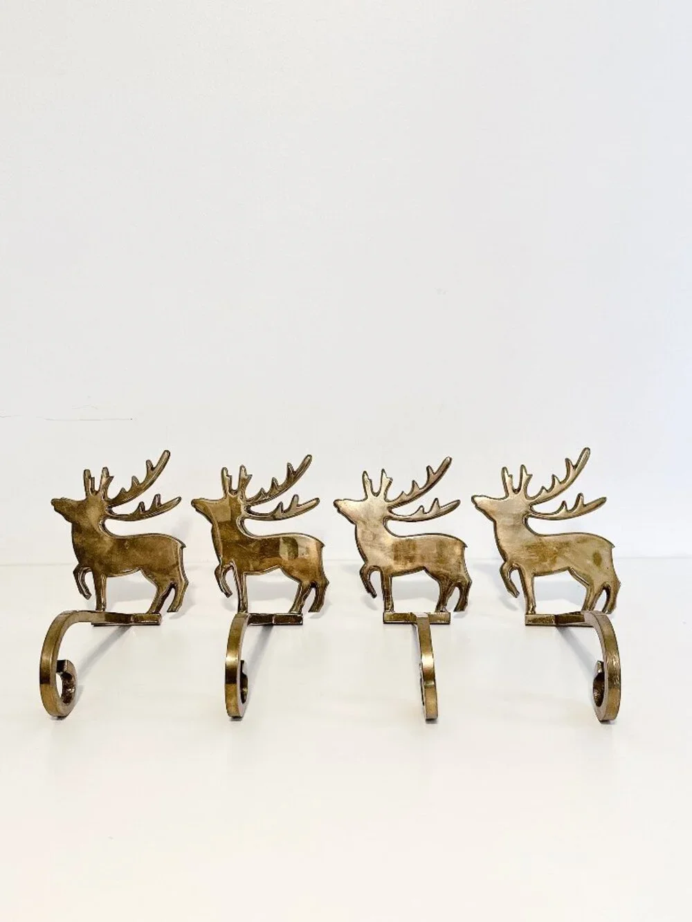 SET OF FOUR BRASS REINDEER MANTEL STOCKING HANGERS